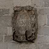 Ai lati del portone sono presenti due stemmi. Il primo reca la scritta Memento Mori (�Ricordati che devi morire�)...